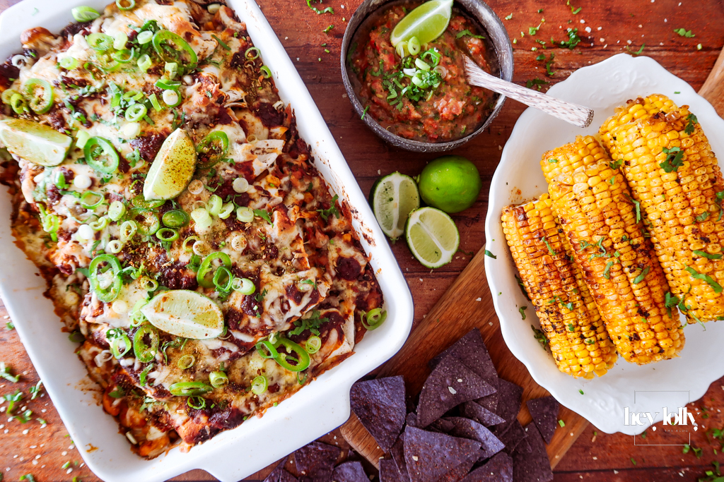 overhead shot of sweetcorn and butter bean enchiladas with salsa and tortilla chips