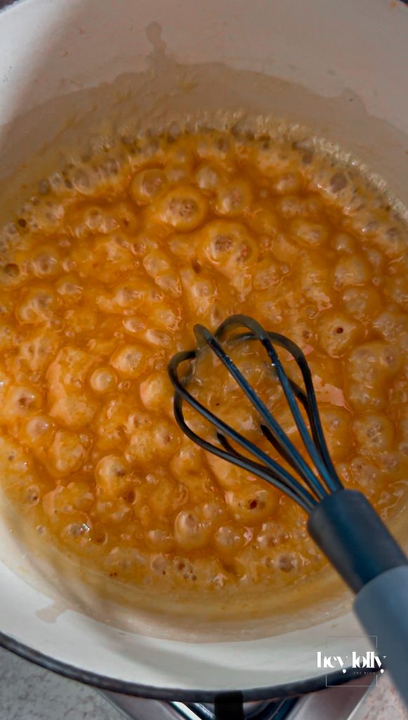 White miso whisked into hot caramel; steamy and slightly seized before smoothing.