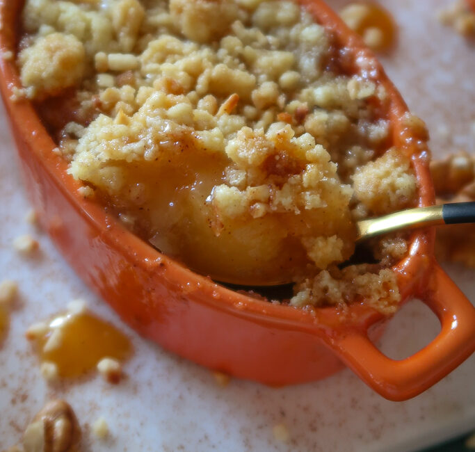 close up of spoon in apple and miso caramel crumble pot