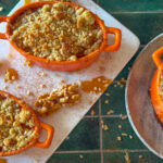 Apple and miso caramel crumble in white ramekins, bronzed sandy topping and glossy caramel drizzle.