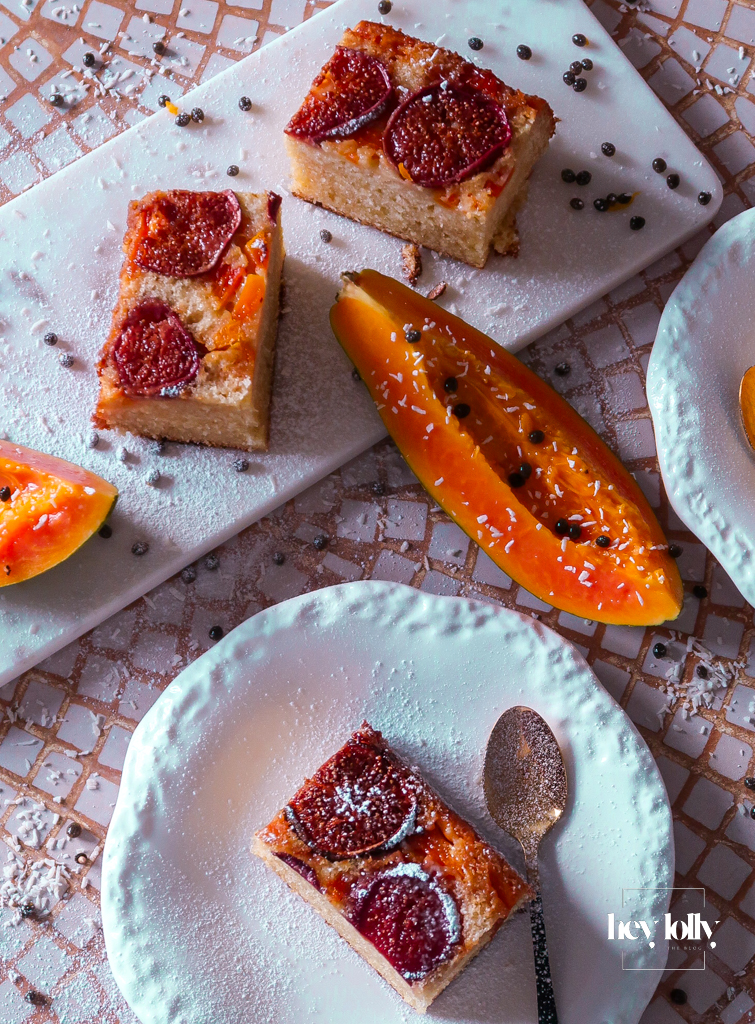 Mini fig and papaya upside-down cakes with glossy fruit tops on a cooling rack