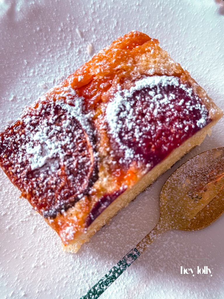 Mini fig and papaya upside-down cakes with glossy fruit tops and dusting of icing sugar