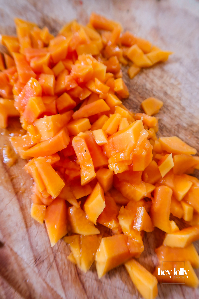 Chopped fresh papaya on a board ready for upside-down cakes