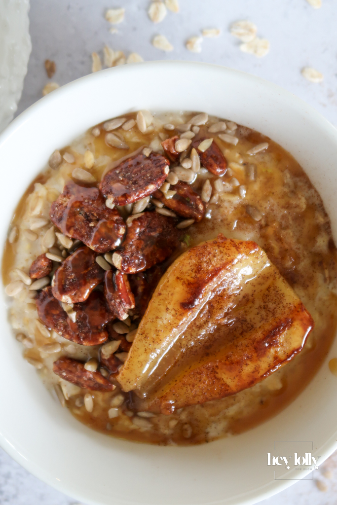 Porridge bowl topped with caramelised pears, pecans, and miso-maple drizzle – Maple-pear & pecan porridge with miso-maple swirl — cosy autumn breakfast bowl.