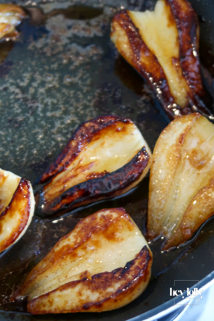 Pears caramelising in butter and maple syrup – Pear slices caramelising in maple syrup and butter for a golden, autumn porridge topping.