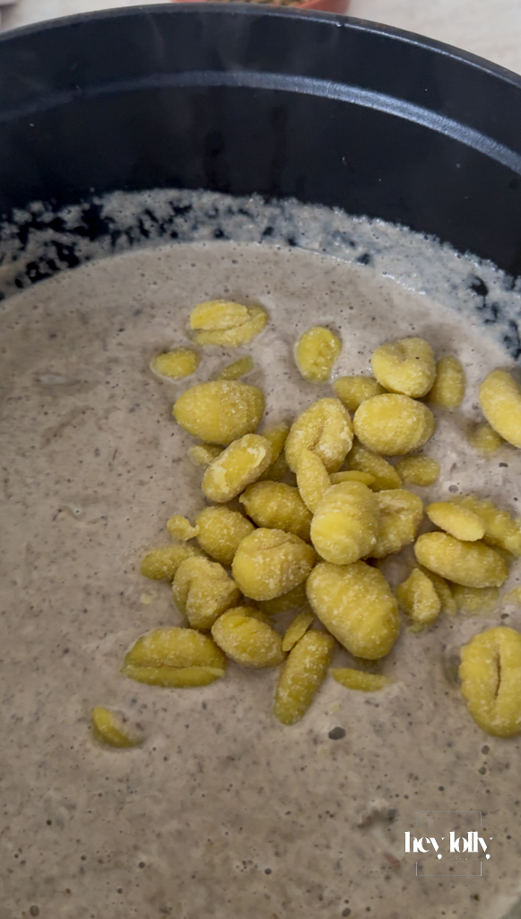 Gnocchi dropped into the pot, a few pieces floating to the top when cooked.