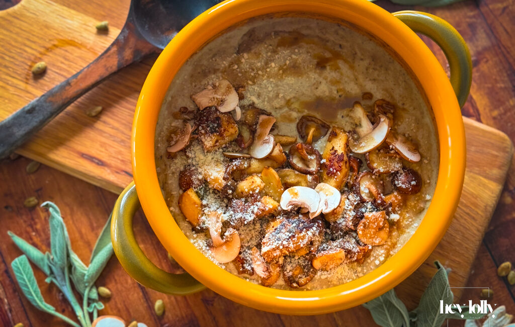 Close-up bowl of mushroom gnocchi soup with bronze mushrooms, thyme and parmesan shavings, steam rising.