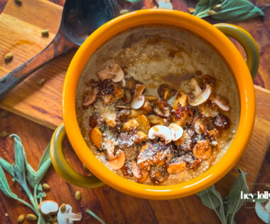 Close-up bowl of mushroom gnocchi soup with bronze mushrooms, thyme and parmesan shavings, steam rising.