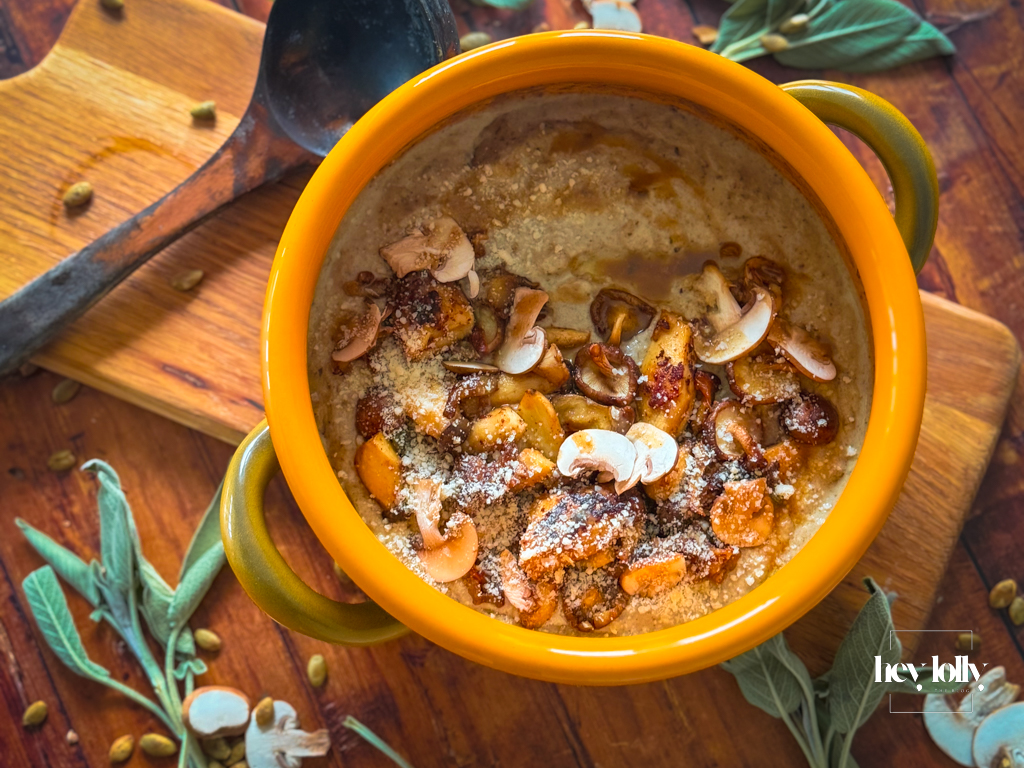 Close-up bowl of mushroom gnocchi soup with bronze mushrooms, thyme and parmesan shavings, steam rising.