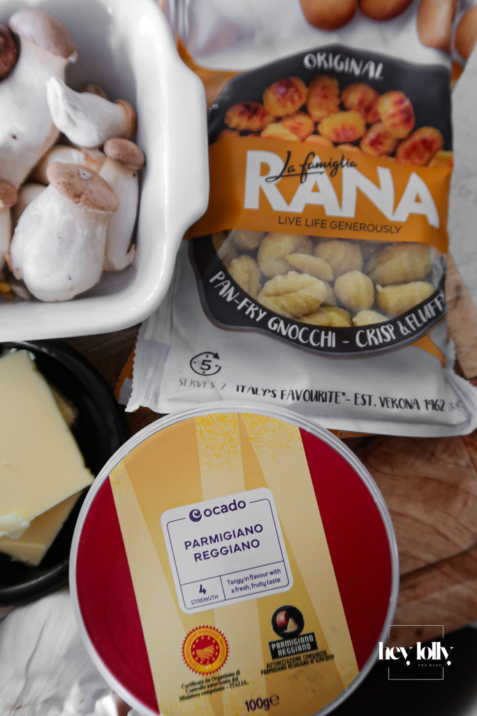 Packet of fresh potato gnocchi next to a jug of vegetable stock and a small pot of cream.