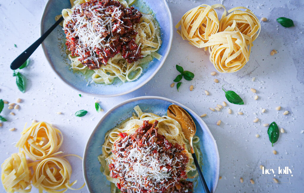 rich beef ragu plated in bowls with tagliatelle and freshly shaved parmesan