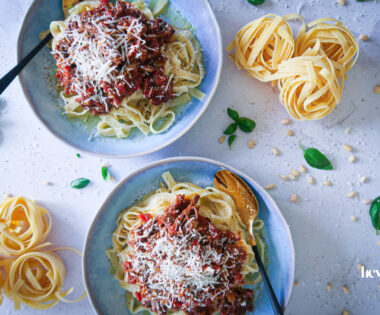 rich beef ragu plated in bowls with tagliatelle and freshly shaved parmesan