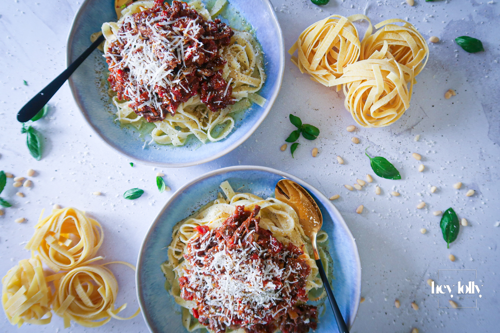 rich beef ragu plated in bowls with tagliatelle and freshly shaved parmesan