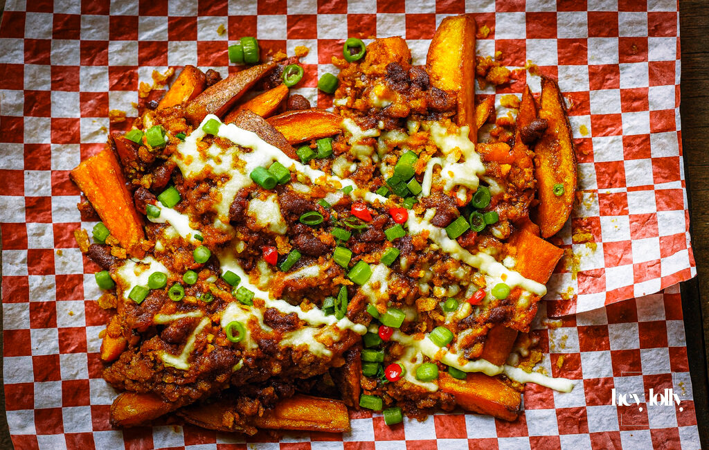 loaded sweet potato fries with sour cream and herbs, ready to share.