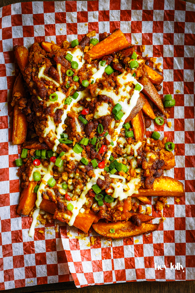 loaded sweet potato fries with sour cream and herbs, ready to share.