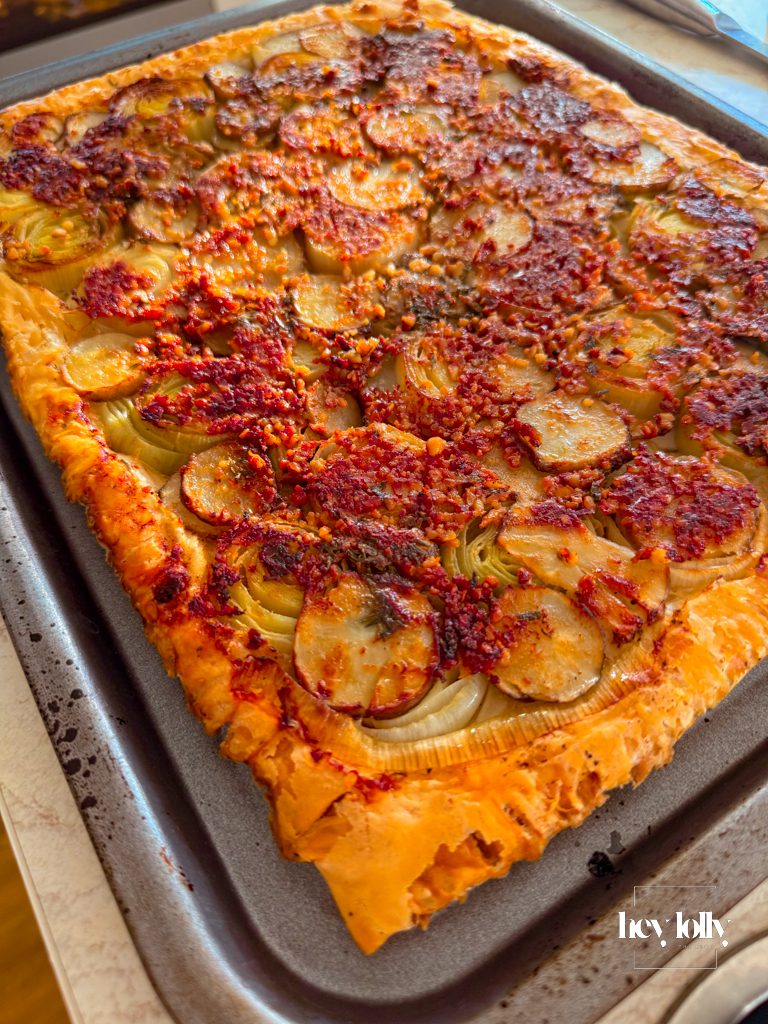 Overhead view of Jerusalem artichoke and leek tart with truffle pesto, baked until lightly golden