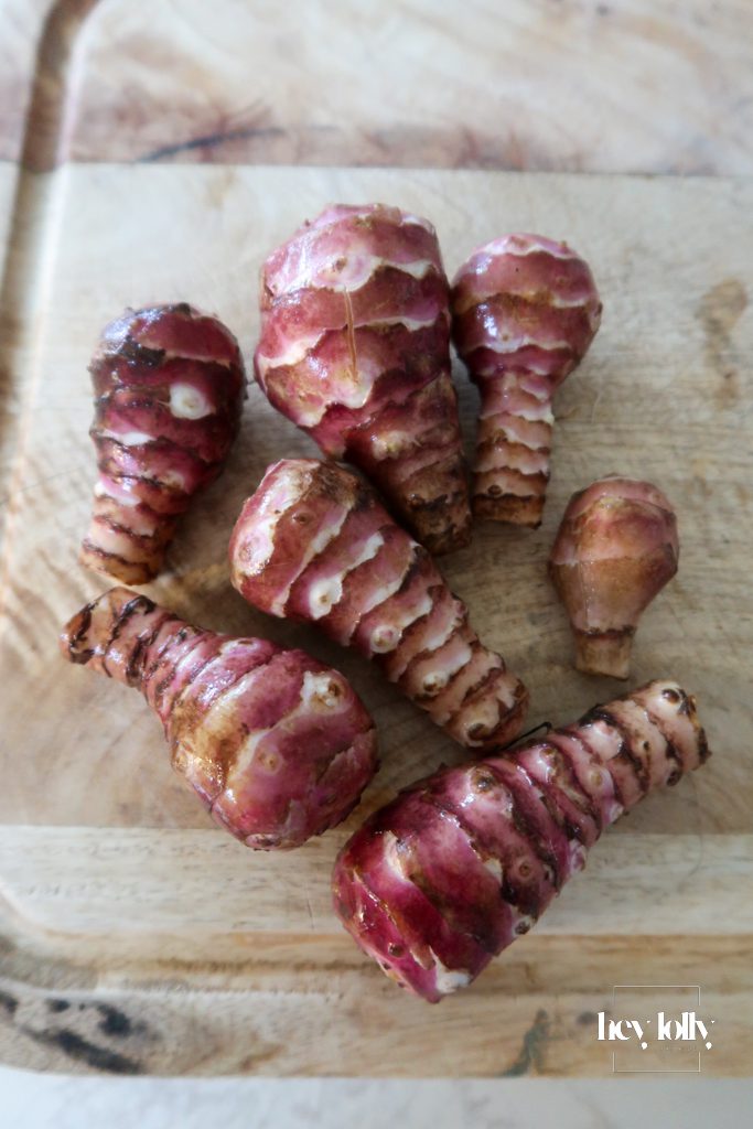Fresh Jerusalem artichokes on a board before peeling and slicing