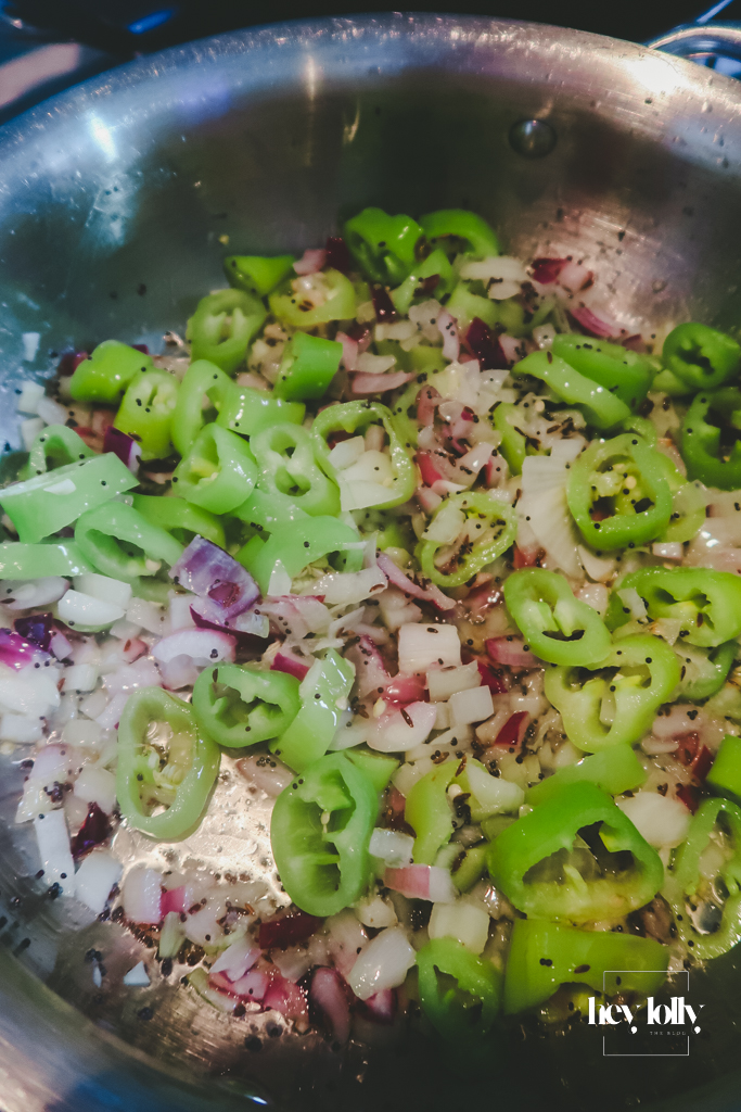 Onions, garlic, ginger and green pepper softening in a pan at the start of the keema
