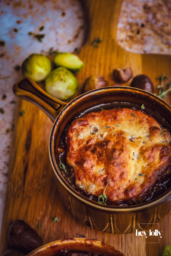 Herby chestnut and cheddar beef cobbler just out of the oven, cobbles risen and deep golden brown.
