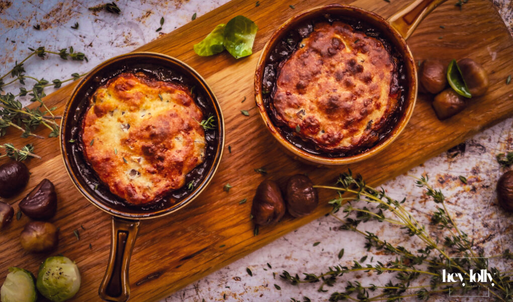 overhead shot of bubbling pots of herby chesnut and cheddar beef cobbler