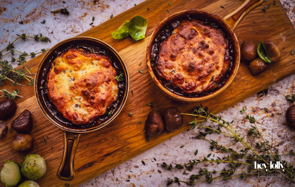 overhead shot of bubbling pots of herby chesnut and cheddar beef cobbler