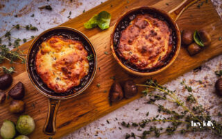 overhead shot of bubbling pots of herby chesnut and cheddar beef cobbler