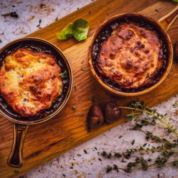 overhead shot of bubbling pots of herby chesnut and cheddar beef cobbler