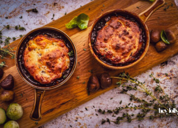 overhead shot of bubbling pots of herby chesnut and cheddar beef cobbler