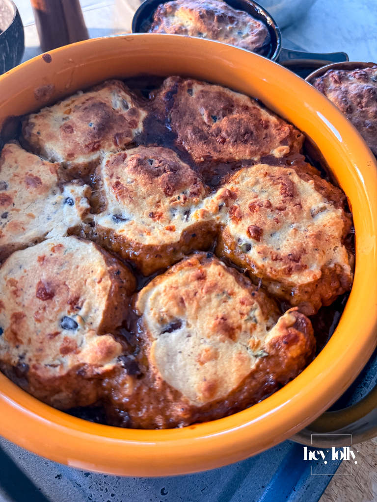 Herby chestnut and cheddar beef cobbler just out of the oven, cobbles risen and deep golden brown.