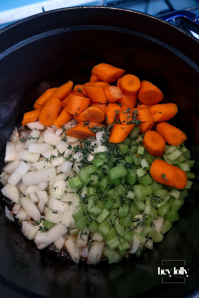 Onions, carrots and celery simmering in a casserole dish as the base for herby beef cobbler.