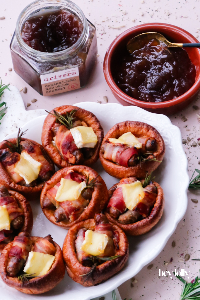 Pigs in blankets Yorkshire puddings with Brie and caramelised onion, festive platter scene.