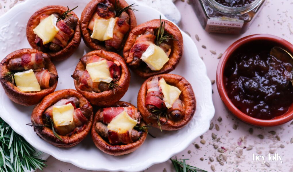 Pigs in blankets Yorkshire puddings with Brie and caramelised onion, festive platter scene.