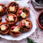 Pigs in blankets Yorkshire puddings with Brie and caramelised onion, festive platter scene.