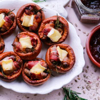 Pigs in blankets Yorkshire puddings with Brie and caramelised onion, festive platter scene.
