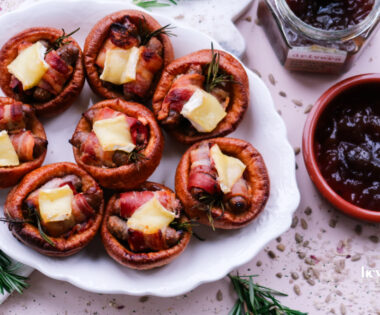 Pigs in blankets Yorkshire puddings with Brie and caramelised onion, festive platter scene.