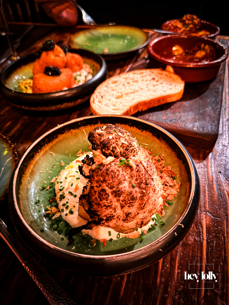 Croquetas de queso y tomate at Plates by Purnell’s – golden mozzarella croquettes piled in a terracotta dish on a rustic wooden table.