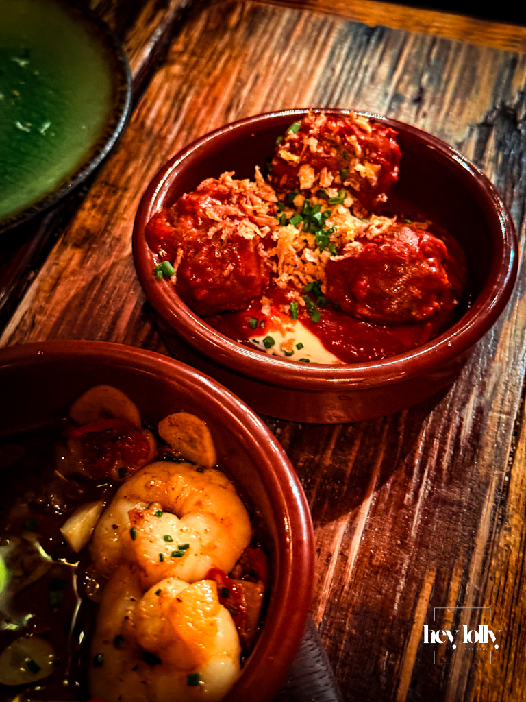 Albondigas at Plates by Purnell’s – three small beef meatballs in tomato sauce topped with crispy onions, in a terracotta dish beside the prawns.