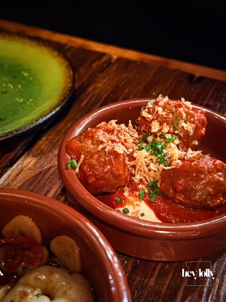 Albondigas at Plates by Purnell’s – three small beef meatballs in tomato sauce topped with crispy onions, in a terracotta dish beside the prawns.