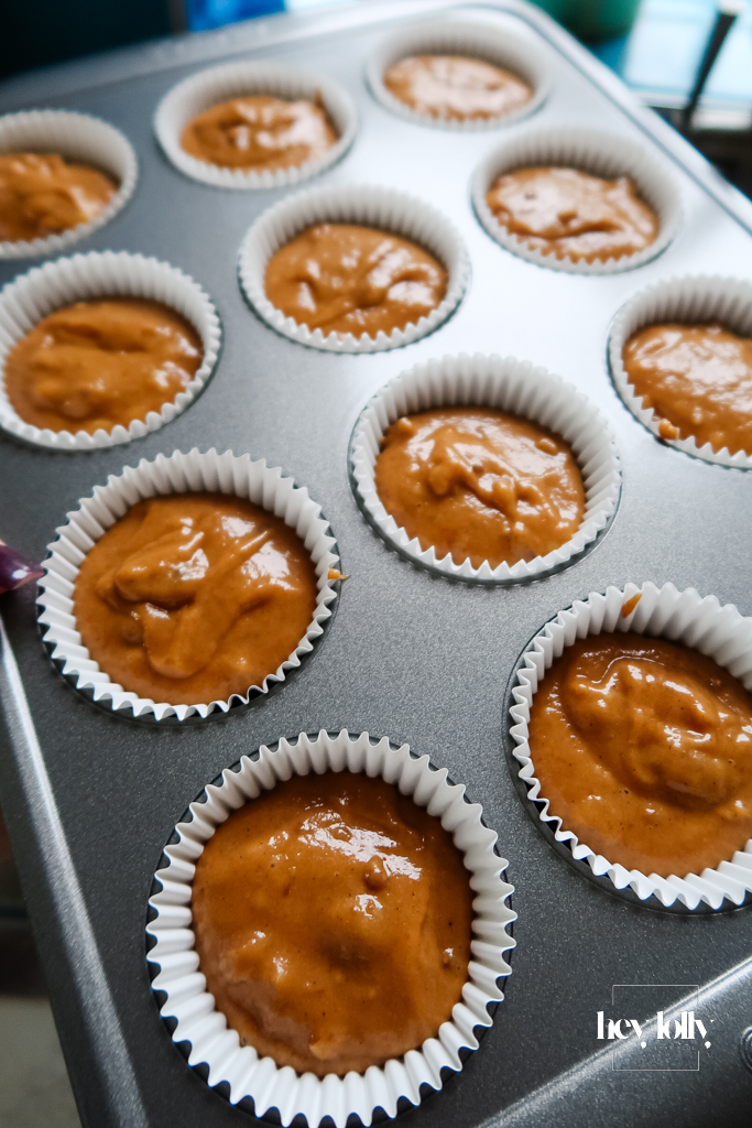 Tray of unbaked Pumpkin, Maple & Pecan Muffins heading to oven, sugar crystals visible.