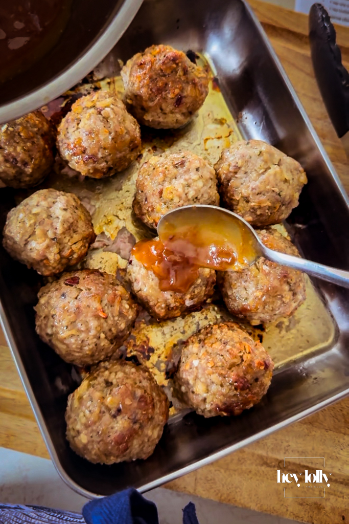 garlic glaze being brushed over roast bombs to gloss.