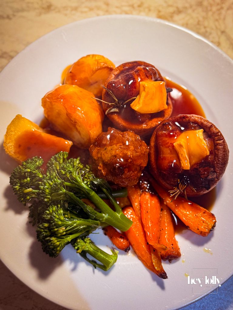 Roast bombs piled over roast potatoes, carrots, sprouts and gravy.