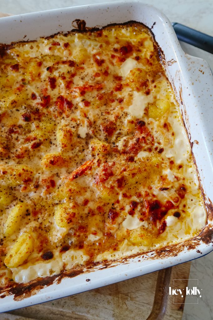 One-pot salmon and fennel gnocchi bake in an oven dish with golden Parmesan topping and burst cherry tomatoes