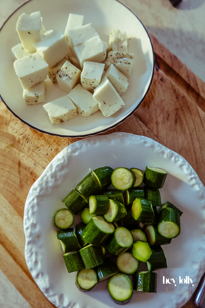 Courgettes sliced into thick rounds; halloumi block ready to cube for threading.