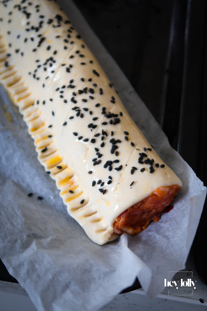 Two even logs of seasoned sausage meat placed along both long edges of the pastry.