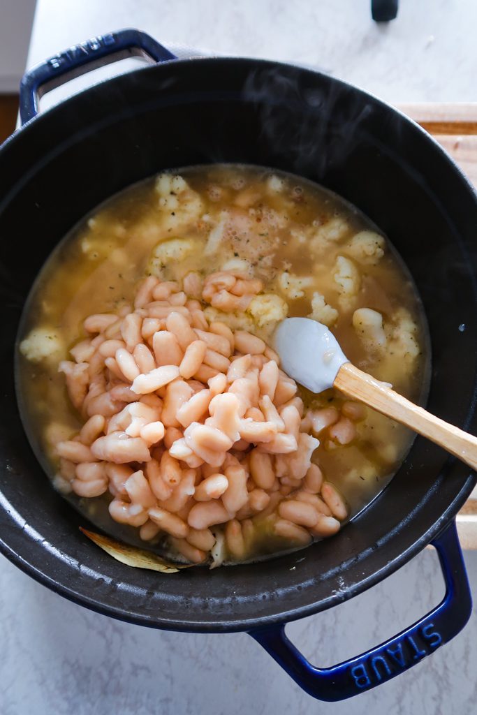 White beans added to cauliflower in the pan for cauliflower and white bean soup