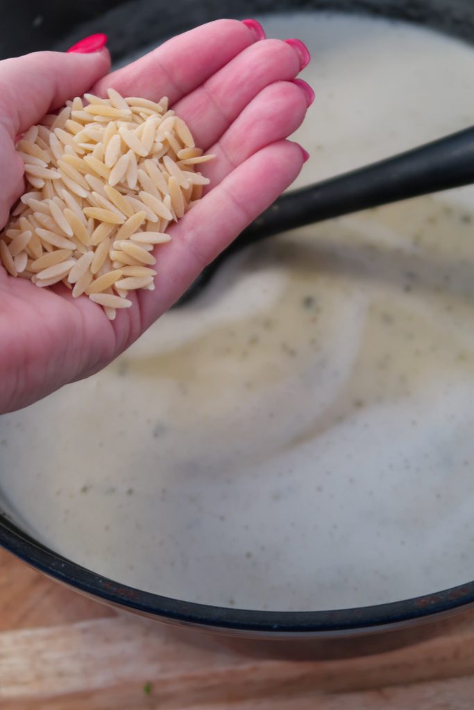 Orzo added to soup base with white beans and stock