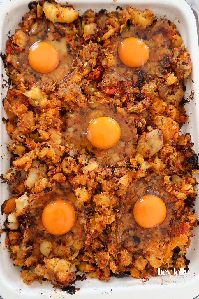 Sunny-side eggs cracked into sprout and harissa potato hash while cooking