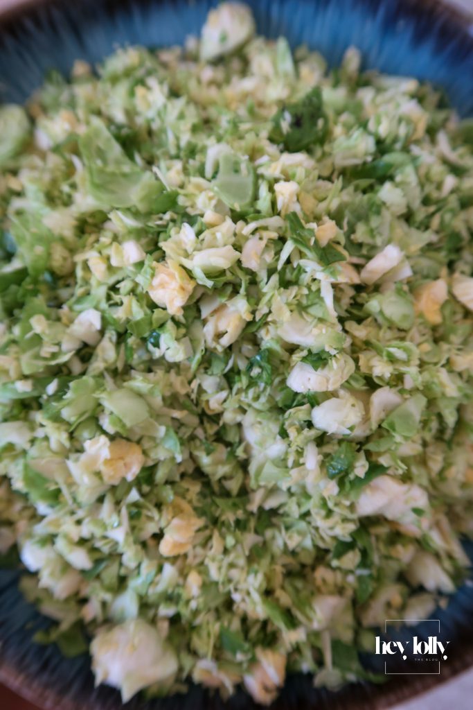 Brussels sprouts added to potato hash with harissa in a large frying pan