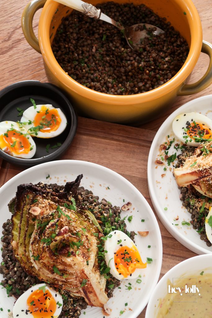 Bowl of warm mustard lentils topped with charred cabbage wedges, jammy eggs and crispy crumbs