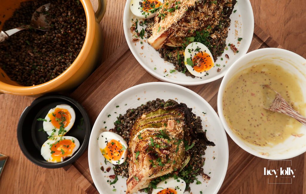 Overhead view of warm mustard lentils with charred cabbage, jammy eggs and garlic breadcrumbs in a shallow bowl